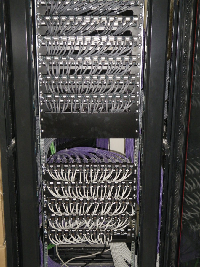 Rack de comunicaciones con patch panels y cableado Ethernet organizado